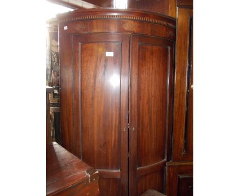 Early 19th Century mahogany bow front hanging corner cabinet, the moulded cornice inlaid with Prince of Wales feathers above 