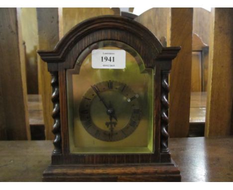 Small 20th Century oak cased mantel clock the brass dial and chapter ring with Roman numerals flanked by barley twist columns