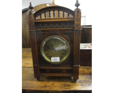 Walnut cased Aesthetic Movement mantel clock with finely carved decoration and circular brass dial with Roman numerals and tw