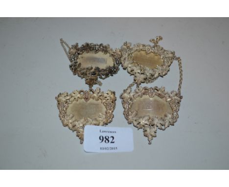 Set of four London silver decanter labels with cast grape vine pattern borders