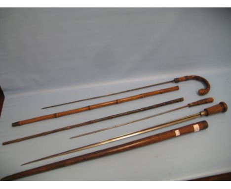 Late 19th or early 20th Century oak swordstick together with two antique Malacca sword sticks