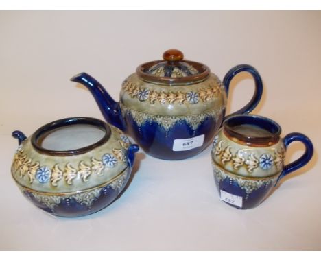 Royal Doulton three piece stoneware tea set with floral relief moulded decoration (small chip to spout)