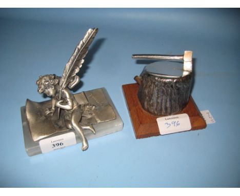 Two modern paper weights in the form of a cherub and an axe in a log