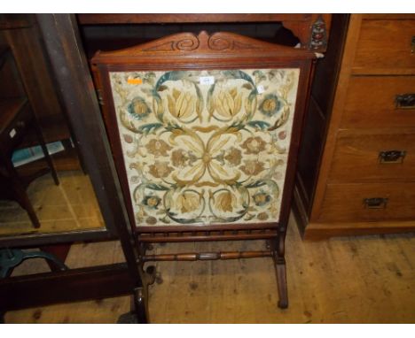 Edwardian oak firescreen inset with a silkwork floral panel on splay supports with turned stretcher