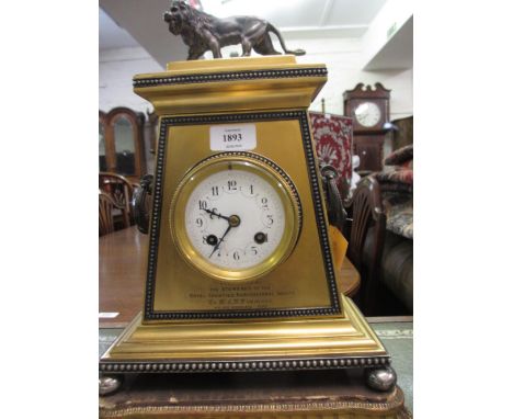 19th Century gilt brass mantel clock of rectangular tapering form with side handles and lion surmount, the enamel dial with A