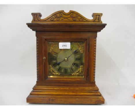 Early 20th Century German oak cased mantel clock, the brass dial with floral spandrels and Roman numerals and two train movem