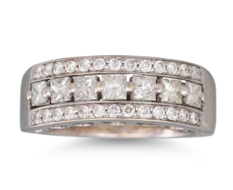 A DIAMOND TRIPLE ROWED RING, the row of princess cut stones flanked by round brilliant cut diamonds to a 14ct white gold moun