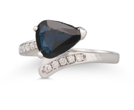 A SAPPHIRE AND DIAMOND RING, the pear shaped sapphire to a cross-over diamond set mount in 18ct white gold, size M - N