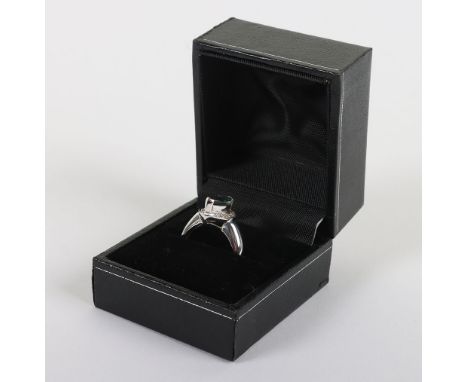 An 18ct white gold diamond and emerald ring, marquise cut emerald over a surround of chip diamonds, emerald 15mmX5mm, 5.7g, i
