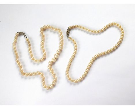 PEARL NECKLACES. Two cultured pearl necklaces, each with a white gold clasp, set a single diamond. Largest beads 10mm & 6mm. 