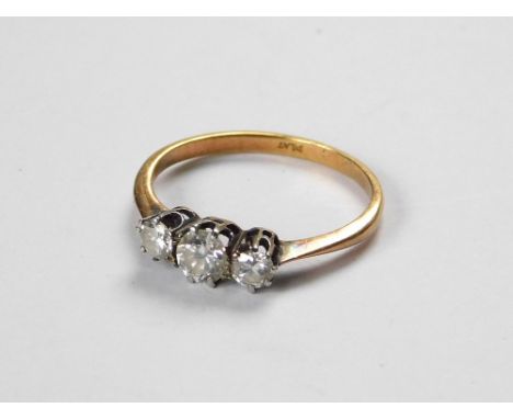 DIAMOND RING. A yellow metal (probably 18ct.) & platinum three stone diamond ring. Size K/L. Approx. 1.6g.  Please note that 