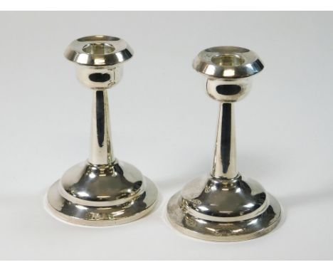 SILVER CANDLESTICKS. A pair of candlesticks with tapering columns. Birmingham 1924. Height 11cm.  Please note that all items 