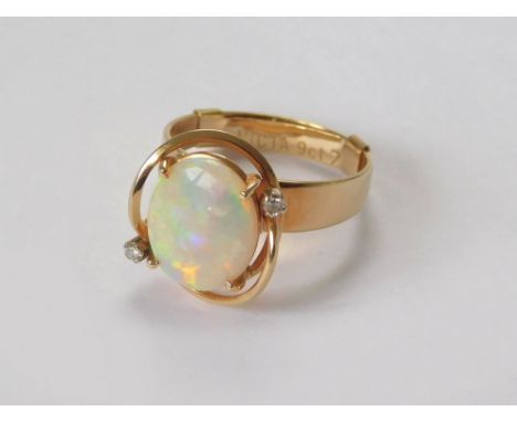 OPAL RING. A 9ct. gold dress ring set a white opal with two offset small diamonds. Fitted a 9ct. gold ring spacer. Size of op