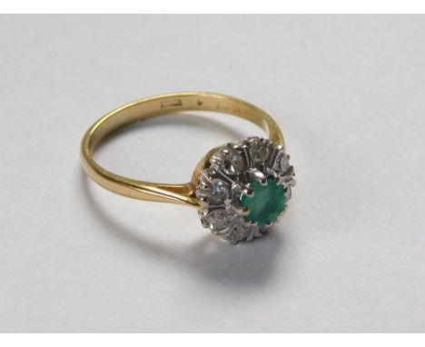 GOLD RING. A 1960's emerald & diamond cluster ring. London 1967. Approx. 3.3g. Size N.  Please note that all items in this au