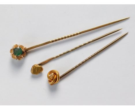 STICK PINS. A Victorian 15ct. gold & diamond set stick pin, an emerald set yellow metal stick pin & a 'gold nugget' stick pin