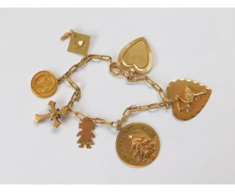 CHARM BRACELET. A 14ct. gold American charm bracelet hung with six 14ct. gold charms & an antique unmarked cross. Gross weigh