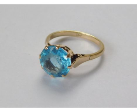 GOLD RING. A 9ct. gold dress ring set a blue topaz stone. Size M/N.  Please note that all items in this auction are previousl