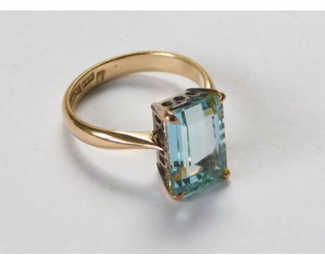 GOLD RING. A 14k. gold dress ring set a rectangular aquamarine coloured stone. Size M.  Please note that all items in this au