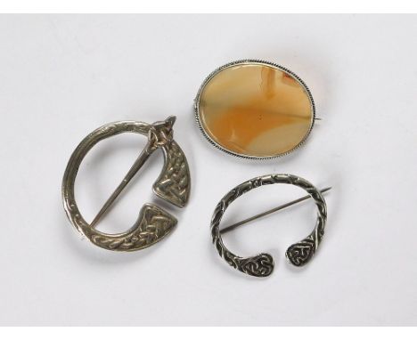 PENANNULAR PIN ETC. A cast silver penannular pin, one other Celtic style cast silver brooch & an agate brooch in silver colou