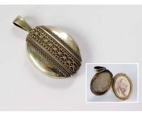 VICTORIAN LOCKET. A Victorian white metal locket with applied decorative band. Length 6.5cm.  Please note that all items in t