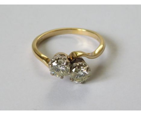 DIAMOND RING. An 18ct. gold, twin stone diamond cross-over ring. Each stone of approx. 0.80ct. spread. Size P.  Please note t