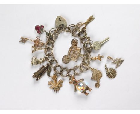 CHARM BRACELET. A double link silver bracelet with padlock clasp & hung with approx. 13 charms, several stamped silver & two 