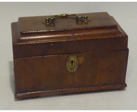 A GEORGE III MAHOGANY TEA CADDY with cable inlaid borders and brass, carrying handle on brass ball feet