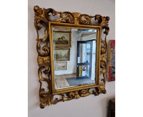 A Chippendale style gilt framed mirror, circa 1900, carved and pierced giltwood frame decorated, bevelled glass, 63cm x 73cm.