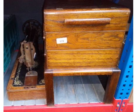 A Singer hand crank sewing machine together with a cantilever sewing box containing various items. 