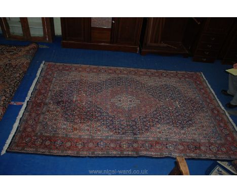 A contemporary bordered, patterned and fringed Eastern Rug, finely decorated against a cream, dark and light blue and pink gr