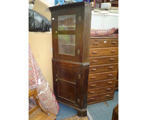 A peg joined 19th c. dark oak corner display cabinet on cupboard base having two glazed panels to the upper section revealing