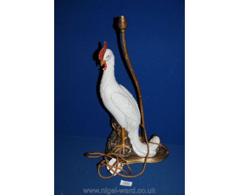 An old Table lamp in the form of a white ceramic bird standing on a rocky outcrop, with ormolu base and simulated bamboo lamp