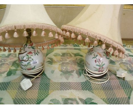 A pair of Chinese style ginger jar table lamps decorated with flora and peaches completed with two pink shades.