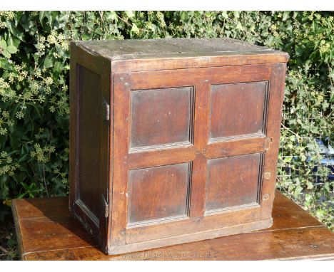 A desirable early Oak Spice Cupboard of peg joyned construction, the recessed door having four panels and opening to reveal a