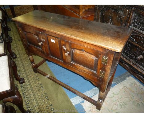 An Old Charm/Priory Oak style compact Sideboard having central rectangular raised and fielded panel flanked by opposing panel