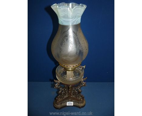 A metal based Oil Lamp with clear reservoir and pretty etched glass shade, 22'' tall, small chips to base.