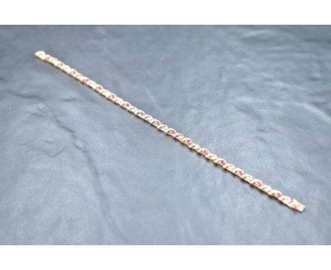A 9ct gold articulated bracelet having ruby and diamond chip decoration with box clasp, approx 180mm long &amp; 5.7g