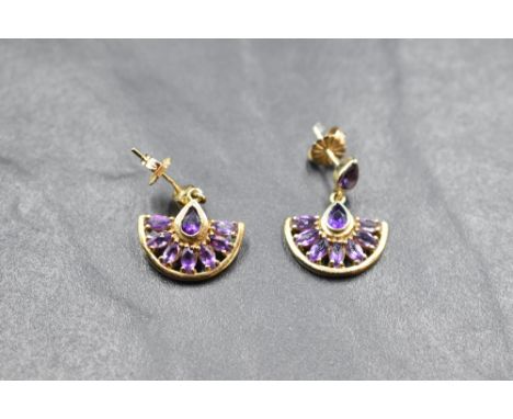 A pair of 9ct gold earrings having small collared teardrop amethyst studs with amethyst set fan drops, approx 4g gross
in goo