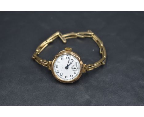 A lady's vintage 9ct rose gold wrist watch having Arabic numeral dial with subsidiary seconds to white enamel face in gold ca