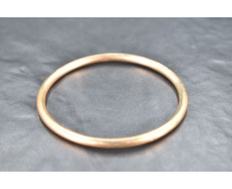 An Edwardian 9ct rose gold slave bangle of plain tubular form, inner diameter 70mm &amp; approx 8.8g
Signs of use, minor mark