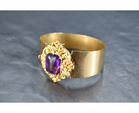 A Victorian yellow metal dual purpose amethyst bangle, the large amethyst in the form of a detachable brooch with an ornate 3