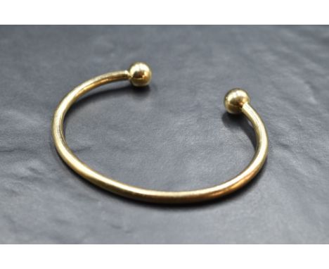 A 9ct gold torque bangle having ball terminals, approx 24.5g
internal dimensions are approx 69mm x 50mm signs of use/wear, ma