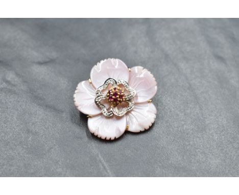 A carved pink shell brooch/pendant in the form of a flower head with diamond and ruby chip decoration to centre with yellow m