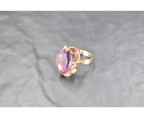 An oval amethyst ring having a claw set stylised mount on a 9ct gold loop, size M &amp; approx 4.7g