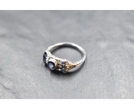 An Edwardian diamond and sapphire ring having a central powder blue sapphire within a bow style mount set with diamonds and f