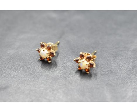 A pair of ruby and opal daisy cluster earrings for pierced ears on yellow metal