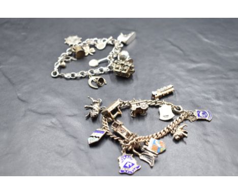 A charm bracelet having twelve white metal and silver charms and shields including steam train, fire engine, etc, and another