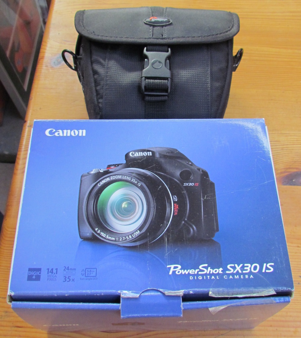 A canon powershot SX30 IS PC1560 digital camera, together with a case