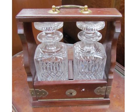 A modern two decanter tantalus with brass mounts