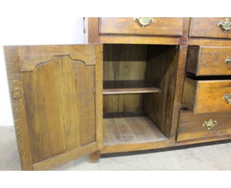 An 18th century style North Wales oak dresser, the rack with a moulded cornice and pierced frieze with three shelves and a se